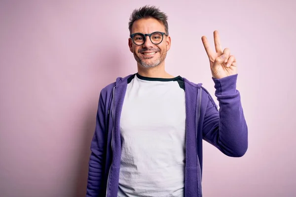 Jovem Homem Bonito Vestindo Camisola Roxa Óculos Sobre Fundo Rosa — Fotografia de Stock