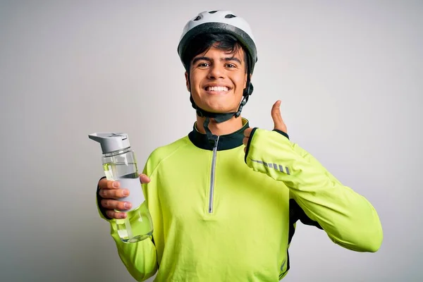 年轻英俊的骑自行车的男人戴着安全帽 喝着一瓶水 开心的笑着做个好手势 用手指竖起大拇指 很好的标志 — 图库照片