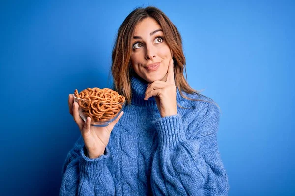 Young Beautiful Brunette Woman Holding Bowl German Baked Pretzels Blue — Stock Photo, Image
