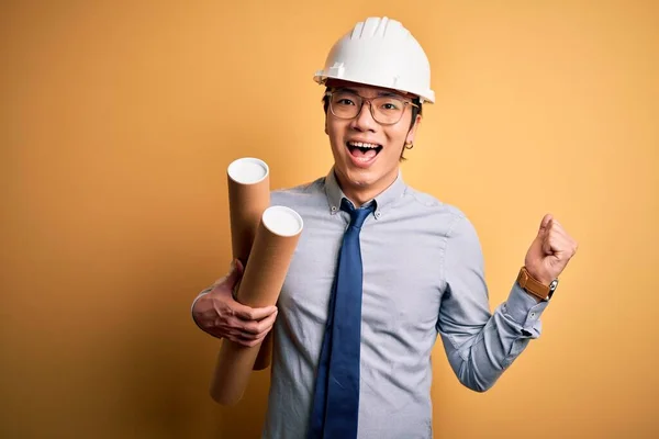 Joven Arquitecto Chino Guapo Con Gafas Casco Seguridad Sosteniendo Planos —  Fotos de Stock