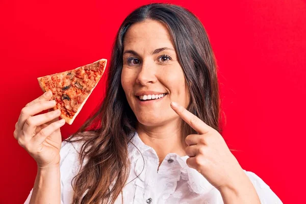 아름다운 갈색의 여성이 위에서 손가락으로 행복하게 가리키며 이탈리아 피자를 — 스톡 사진