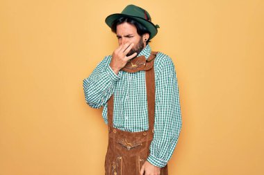 Almanya festivali için geleneksel Alman Ekim Festivali kıyafeti giyen genç yakışıklı adam pis ve iğrenç bir koku alıyor. Nefesini burnunda tutuyor. Kötü kokuyor.