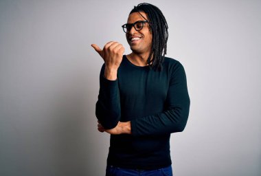 Rastgele tişört ve gözlüklerle gülümseyen, gülümseyen ve baş parmağıyla yüzünü gösteren Afro-Amerikan genç yakışıklı adam..