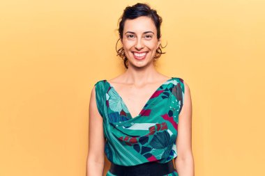 Genç, güzel, İspanyol bir kadın mutlu ve havalı bir gülümsemesi olan gündelik kıyafetler giyiyor. şanslı kişi. 