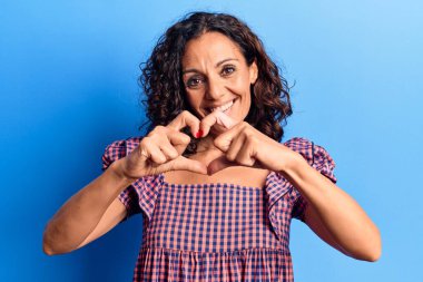 Orta yaşlı, güzel bir kadın. Sıradan tişörtler giyiyor. Sevgiyle gülümsüyor. romantik kavram. 