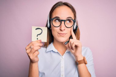 Güzel bir çağrı merkezi ajanı, elinde kulaklıkla çalışıyor. Yüzünde soru işareti var. Soru üzerine kafa karıştırıcı bir fikir.