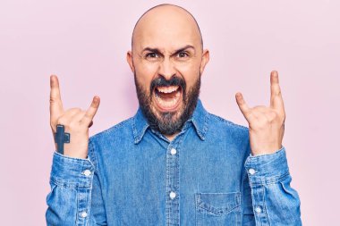 Genç, yakışıklı, günlük kıyafetler giymiş, çılgın bir ifadeyle bağıran, elleri havada rock sembolü yapan bir adam. Müzik yıldızı. ağır kavram. 