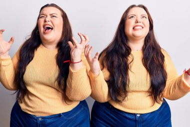 Genç ve cüsseli ikizler gündelik kıyafetler giyip deli gibi bağırıyor ve agresif bir ifade ve kollarla bağırıyor. hüsran kavramı. 