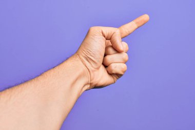 İzole edilmiş mor arka planda parmaklarını gösteren beyaz bir gencin eli işaret parmağı kullanarak bir numarayı sayıyor, fikir ve anlayış gösteriyor.