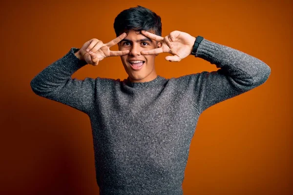 Jovem Homem Bonito Vestindo Camisola Casual Sobre Fundo Laranja Isolado — Fotografia de Stock