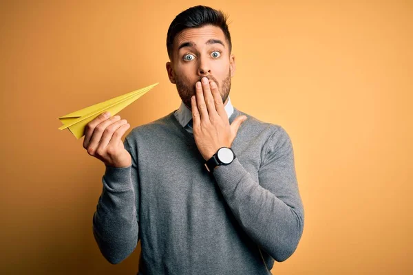 Joven Hombre Guapo Sosteniendo Avión Papel Pie Sobre Boca Cubierta —  Fotos de Stock