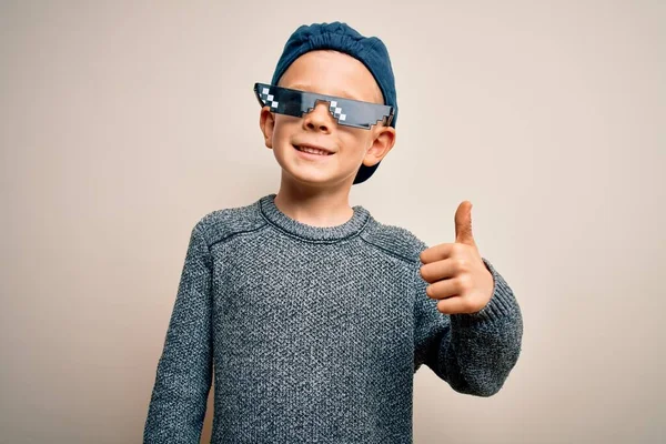 孤立した背景の上にインターネットミームのつま先の生命ガラスを身に着けている若い白人の子供は手で幸せな親指のジェスチャーをする 成功を示すカメラを見て表現を承認する — ストック写真