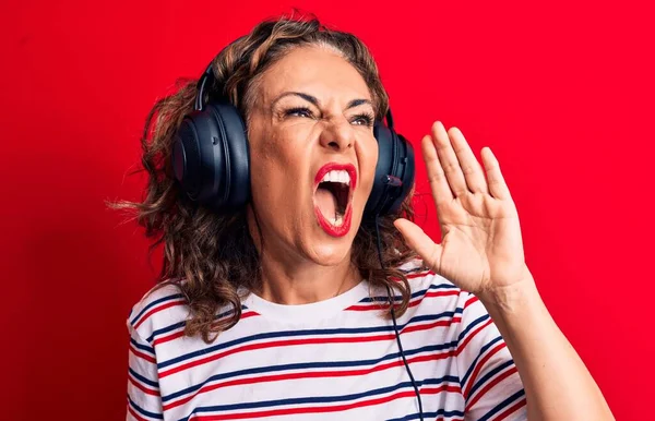 中世のブルネットのゲーマーの女性は ヘッドフォンやマイクの叫びを使用してビデオゲームをプレイし 口の中で手で横に大声で叫ぶ コミュニケーションの概念 — ストック写真
