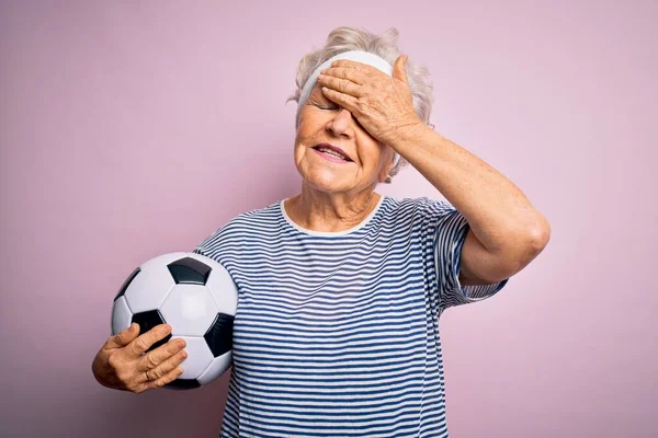 Старшая Красивая Седовласая Женщина Держащая Футбольный Мяч Стоящий Розовом Фоне — стоковое фото