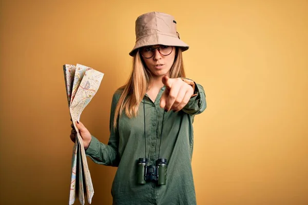 Blonde 탐험가인 모자를 쌍안경을 휴가중이다 카메라를 가리키는 지도를 — 스톡 사진