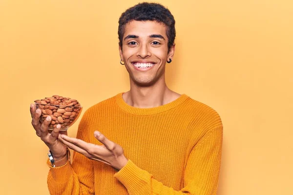 Young African Amercian Man Holding Bowl Almonds Looking Positive Happy — Stock Photo, Image