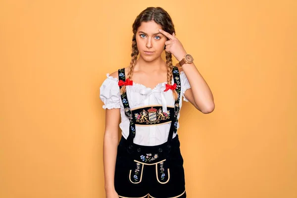年轻美丽的金发德国女人 蓝眼睛 穿着传统的十月节礼服 不高兴地指出额头上的粉刺 丑陋的黑头感染 粉刺和皮肤问题 — 图库照片
