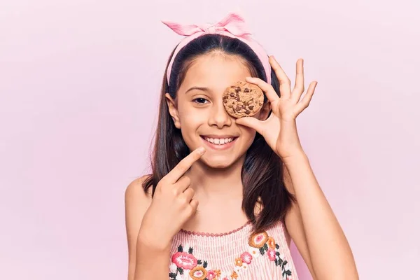 Hermosa Niña Sosteniendo Galleta Sonriendo Feliz Señalando Con Mano Dedo — Foto de Stock