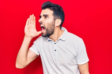 Sakallı, sıradan polo giyen, el ele tutuşup bağıran genç yakışıklı bir adam. iletişim konsepti. 