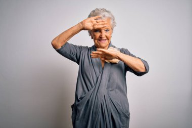 Son sınıf güzeli, gri saçlı, sıradan bir elbise giyen, beyaz arka planda dikilen, gülümseyen, güler yüzlü, elleri havada dikizleme oyunu oynayan bir kadın. Şaşırdım ve çıktım.
