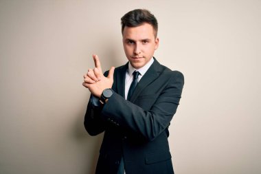 Zarif takım elbiseli ve kravatlı genç yakışıklı iş adamı. Sembolik silahı elinde tutuyor. El hareketleriyle cinayet silahlarıyla oynuyor.