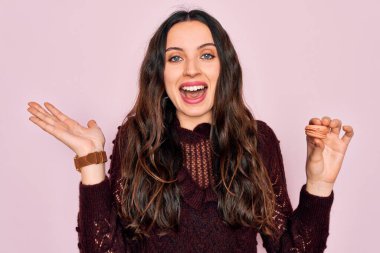 Mavi gözlü genç bir kadın Fransız usulü tatlı yiyor. Çok mutlu ve heyecanlı. Kazanan ifade zaferi kutluyor.