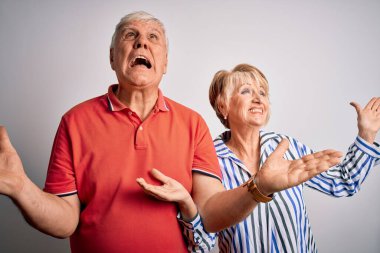 Tecrit edilmiş beyaz arka planda bir arada duran son sınıf güzeli çift kızgın ve çılgın bir şekilde bağırıyor ve agresif bir ifadeyle ve kollarını kaldırarak bağırıyor. Hayal kırıklığı konsepti.