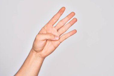 İzole edilmiş beyaz arka planda parmaklarını gösteren Kafkas delikanlısının eli 4 numarayı gösteriyor.