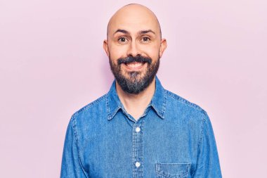 Yüzünde mutlu ve havalı bir gülümseme olan sıradan kıyafetler giyen genç yakışıklı bir adam. şanslı kişi. 