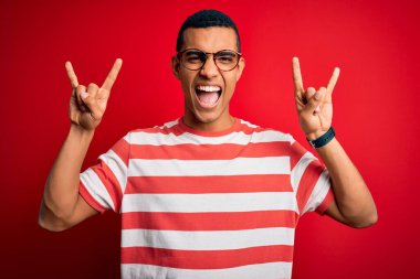 Genç, yakışıklı, Afro-Amerikalı, sıradan çizgili tişört ve gözlük giymiş çılgın bir ifadeyle bağıran elleri havada rock sembolü yapan bir adam. Müzik yıldızı. Ağır müzik konsepti.