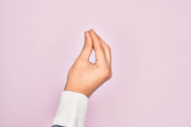 İzole edilmiş pembe arka planda parmaklarını gösteren beyaz bir adamın eli parmaklarıyla İtalyanca jest yapıyor, iletişim hareketi yapıyor.