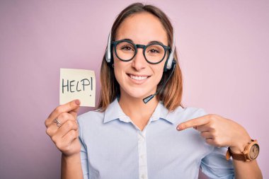 Güzel çağrı merkezi ajanı kadın kulaklık kullanarak çalışıyor. Hatırlatmaya yardım ediyor. Yüzü kendini işaret ediyor.