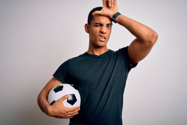 Yakışıklı Afro-Amerikalı adam futbol topunu beyaz arka planda tutuyor. Alnında parmakları olan insanlarla alay ediyor. Ezik jestler yapıyor, alay ediyor ve hakaret ediyor..