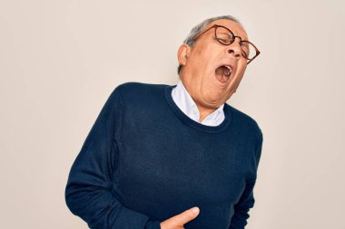 Yaşlı yakışıklı, gri saçlı, süveter ve gözlük takan, midesi bulanan, acı verici bir hastalıktan dolayı el üstünde beyaz bir arka plan giyen bir adam. Ache kavramı.