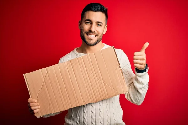 Joven Hombre Guapo Sosteniendo Pancarta Cartón Blanco Sobre Fondo Rojo — Foto de Stock