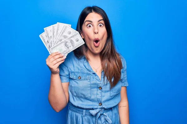Genç Güzel Esmer Bir Kadın Elinde Dolarlarla Izole Edilmiş Mavi — Stok fotoğraf