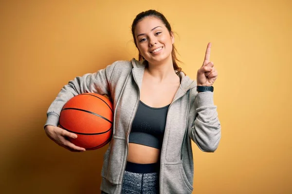 Sarı Zemin Üzerinde Basketbol Topu Tutan Güzel Esmer Bayan Bir — Stok fotoğraf