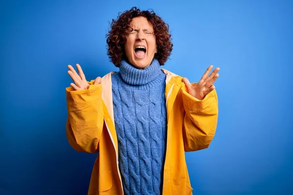 Middelbare Leeftijd Krullend Haar Vrouw Dragen Regenjas Staan Geïsoleerde Blauwe — Stockfoto