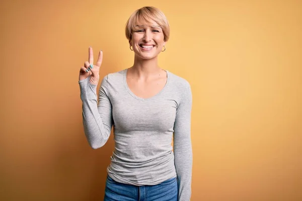 Sarı Arka Planda Duran Modern Kısa Saçlı Genç Sarışın Kadın — Stok fotoğraf