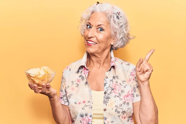 Mulher Cabelos Grisalhos Sênior Segurando Chip Batata Sorrindo Feliz Apontando — Fotografia de Stock