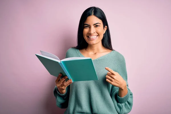 Joven Hermosa Estudiante Hispana Leyendo Libro Sobre Fondo Rosa Aislado — Foto de Stock