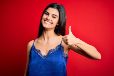Zarif ve rahat iç çamaşırları giyen genç, güzel esmer kadın elinle mutlu parmaklar hareketi yapıyor. Kameraya bakıp başarıyı gösteren ifade onaylanıyor.