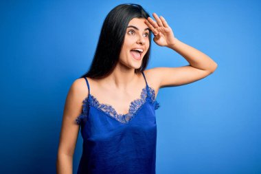 Zarif ve rahat mavi iç çamaşırı giyen genç, güzel esmer kadın çok mutlu ve gülümsüyor. Konsept aranıyor.