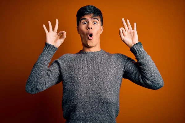 Jovem Homem Bonito Vestindo Camisola Casual Sobre Fundo Laranja Isolado — Fotografia de Stock