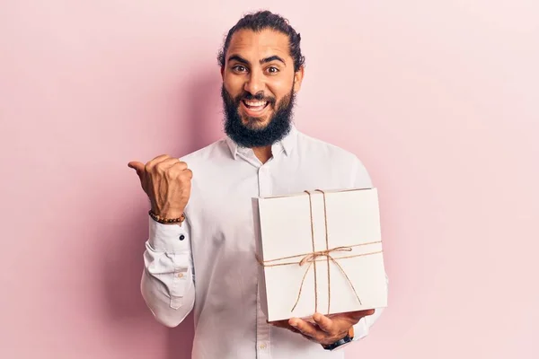 Ung Arabisk Man Håller Gåva Pekar Tummen Upp Till Sidan — Stockfoto