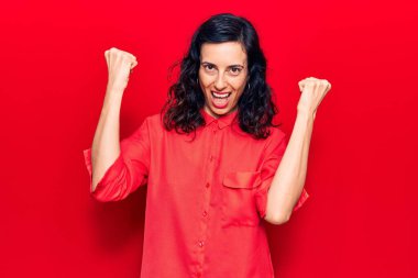 Genç ve güzel İspanyol kadın gündelik kıyafetler giyip gururla bağırıyor zaferi ve başarıyı kutluyor. Kollarını kaldırıp heyecanla bekliyor. 