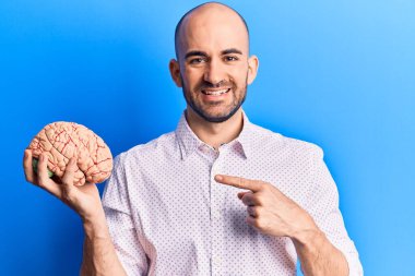 Beyni tutan yakışıklı kel adam gülümsüyor. 