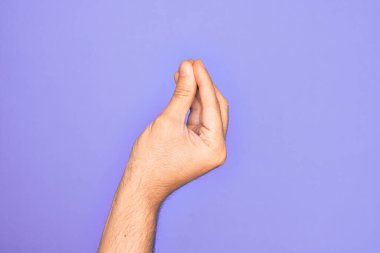 İzole edilmiş mor arka planda parmaklarını gösteren beyaz bir gencin eli parmaklarıyla İtalyanca jest yapıyor, iletişim hareketi yapıyor.