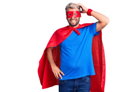 Süper kahraman kıyafeti giyen genç sarışın adamın kafası karışıyor ve soru sormayı merak ediyor. Şüpheyle kararsız, kafa kafaya düşünerek. Düşünceli kavram. 