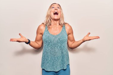 Orta yaşlı beyaz kadın spor kıyafetleri giyiyor deli gibi bağırıyor, bağırıyor, agresif bir ifade ve kollarla bağırıyor. hüsran kavramı. 